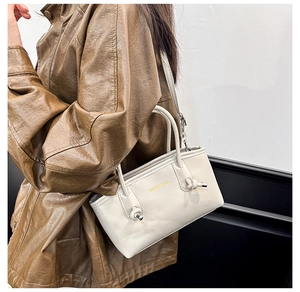 Detail of ivory tote bag featuring knot handle design and gold Fashion & Bags lettering