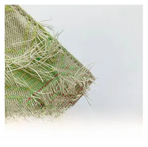 Détail de la texture tissée avec motifs roses et verts et bordures effilées