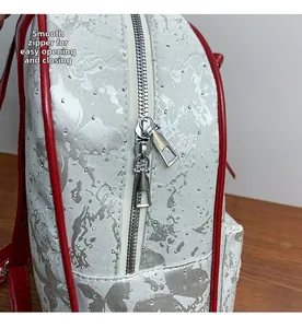 Detail of silver jacquard backpack with smooth dual metal zippers and red leather piping