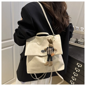 Detail of off-white faux leather tote with metal twist lock and cute bunny pendant