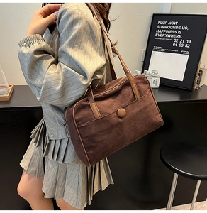 Detail of a vintage dark brown tote bag on model showing premium suede texture and strap