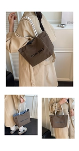Detail of a brown canvas tote bag featuring rope handles and black TOTE BAG lettering