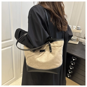 Details der gesteppten Canvas-Tasche mit schwarzem Lederbesatz und weißen Nähten
