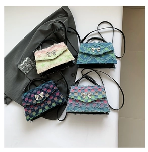 Detail of four colorful denim crossbody bags with frayed edges and bow hardware