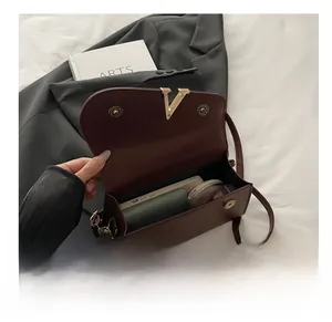 Detail of burgundy crossbody bag interior showing storage space for phone and makeup