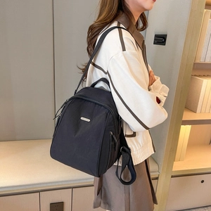 Seitenansicht eines schwarzen Nylon-Rucksacks mit edlem Metall-Logo für Damen und Herren