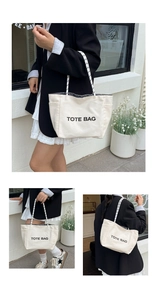 Close-up of canvas tote bag featuring letter print and striped handles for commuting