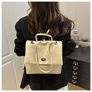 Chic cream leather backpack with metal turn-lock closure shown on model in studio