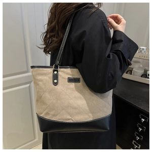 Beigefarbene Stepp-Tote-Bag mit schwarzen Lederakzenten an der Schulter in moderner Optik