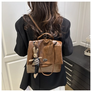 Detailed view of brown PU leather backpack with vintage metal lock and rabbit charm