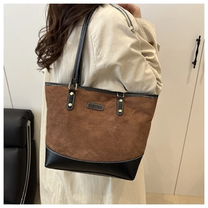 Detail of the brown quilted suede tote bag showing contrast stitching and FASHION tag