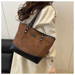 Detail of contrast stitch tote bag with brown suede finish and black leather trim