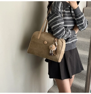 Khaki suede shoulder tote bag with cute plush sheep pendant shown in lifestyle setting