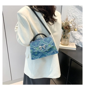Detail of vintage patchwork denim handbag with star patterns and silver bow clasp
