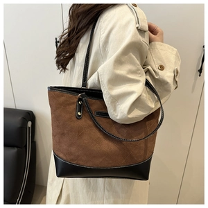 Detail of vintage quilted tote bag featuring brown suede and black leather patchwork design