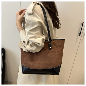 Detail of vintage patchwork tote bag with diamond quilted texture and long leather straps