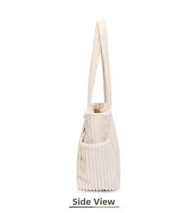 Side view of white corduroy tote bag showing textured stripes and side pocket detail