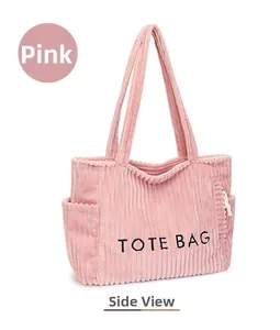 Détail d'un sac cabas en velours côtelé rose avec texture rayée et imprimé TOTE BAG