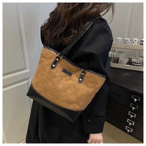 Detail of vintage quilted tote bag with brown suede and black trim stitching