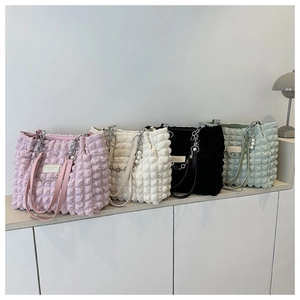 Macro-opname van tote bags met bubbeltextuur in de kleuren roze wit zwart en groen