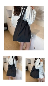 Detail of minimalist nylon drawstring shoulder bag showing waterproof fabric and large capacity