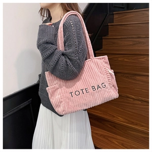 Close-up of pink corduroy tote bag showing textured fabric and TOTE BAG embroidery