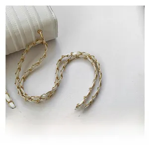 Detail of the white quilted leather bag showing gold metal chain strap and fine texture