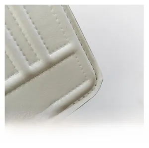 Detailed close-up of quilted white leather texture and fine stitching on woman crossbody bag