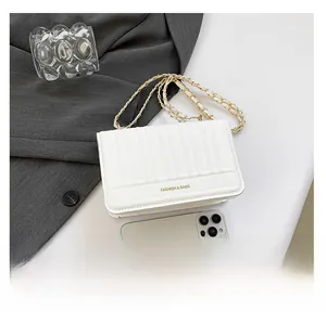 Detailed view of white quilted faux leather bag with gold chain and mobile phone size comparison