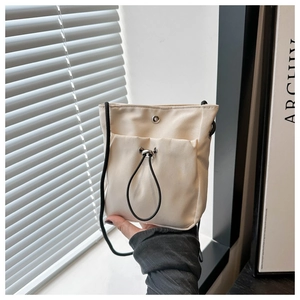 Detail van crème nylon crossbody emmertas met zwart trekkoord en zilveren gesp