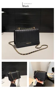 Close-up of black quilted shoulder bag featuring gold chain and fashion logo detail