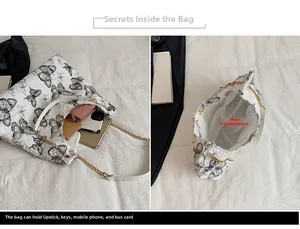 Dettaglio della borsa tote con farfalle che mostra lo scomparto principale e gli oggetti