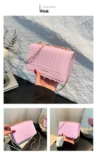 Detailed close-up of a pink quilted crossbody bag with a gold chain strap and logo