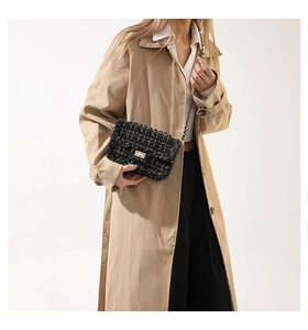 Dettaglio borsa a tracolla in tweed nero con catena dorata indossata da modella