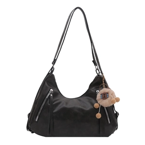 Versatile black faux leather hobo backpack with fringe zippers and plush monster charm