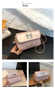 Detail der rosa Mini-Quadrat-Tasche mit Metall-Schmetterlingsschleife und Textur