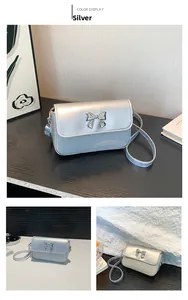 Detailansicht einer silbernen Pailletten-Handtasche mit Metallschleife und Lederriemen