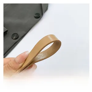 Close-up of the textured brown synthetic leather shoulder strap for a fashion handbag