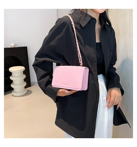 Pink minimalist chain crossbody bag with vertical stripe pattern shown on a female model