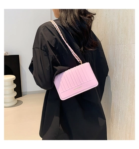 Detail view of pink quilted chain shoulder bag with FASHION & BAGS lettering shown on model