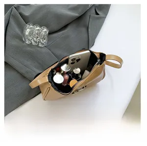 Internal view of khaki baguette bag showing large storage capacity for phone and cosmetics