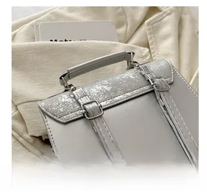 Close-up of adjustable straps and silver cracked texture on light gray backpack