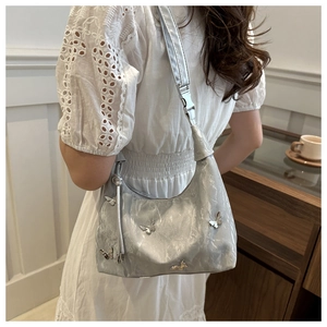 Détail du sac hobo argenté avec papillons métalliques et texture en cuir plissé