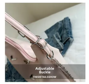 Detail of adjustable silver buckle and metal chain strap on pink butterfly tote bag