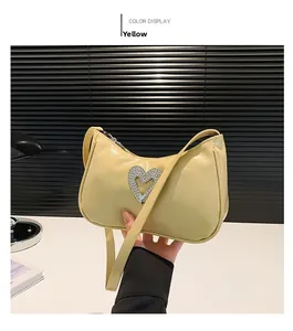 Close-up of yellow shoulder bag featuring a rhinestone heart buckle and cracked texture