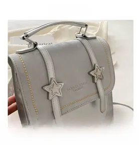 Detail of grey vintage star backpack showing leather texture and silver buckle accents