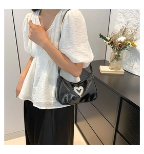 Detail of a black soft PU shoulder bag featuring a sparkling diamond heart metal buckle