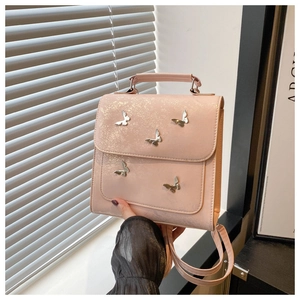Close-up of pink crossbody bag with silver metal butterfly charms and shimmery texture
