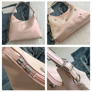 Detailed close-up of silver butterfly charms and chain strap on light pink shoulder bag