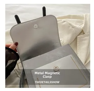 Close-up of magnetic metal snap button and interior flap of women shoulder bag